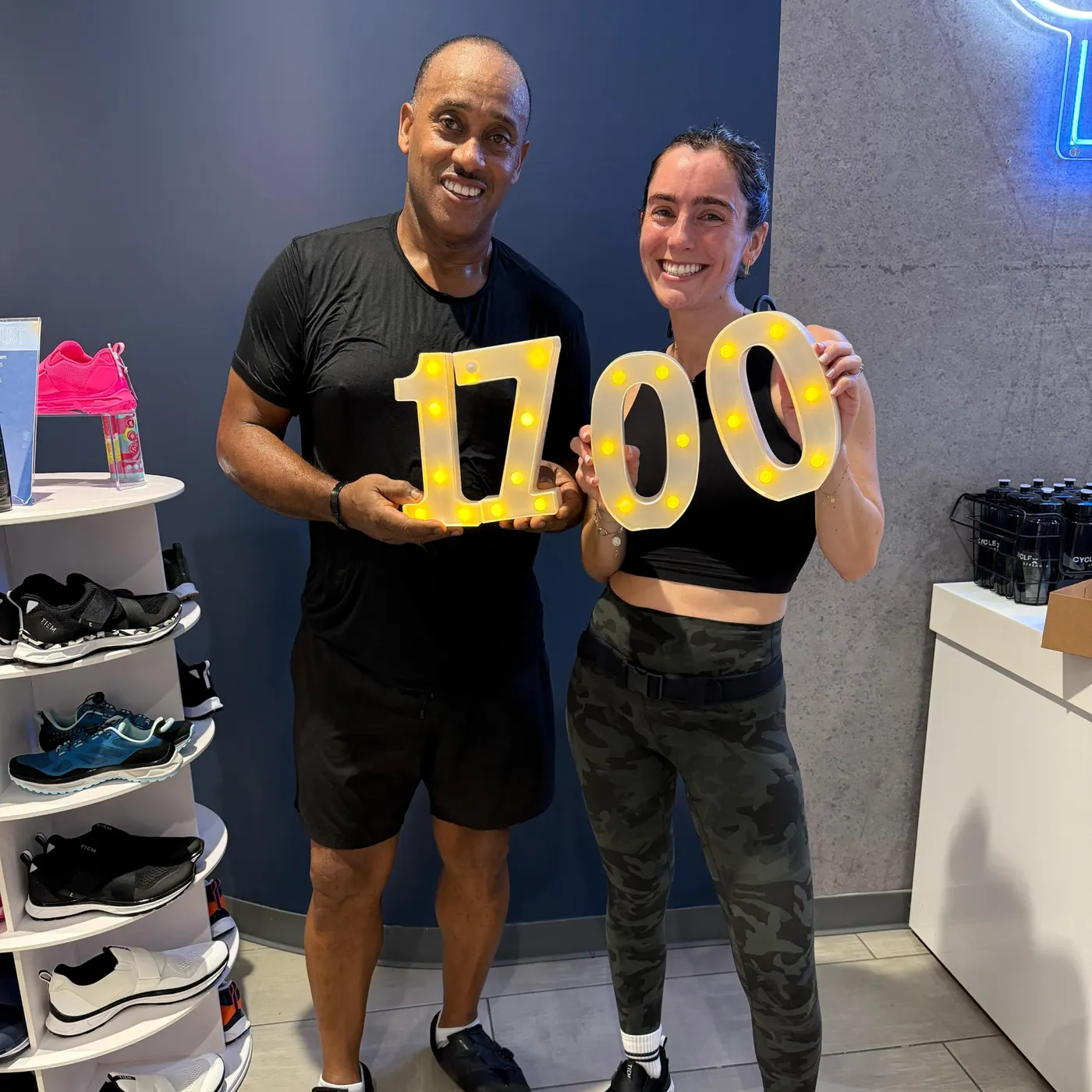 A member and instructor holding lit numbers for his 1,700th class